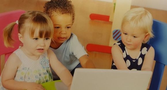 drei kleine Kinder an einem Laptop