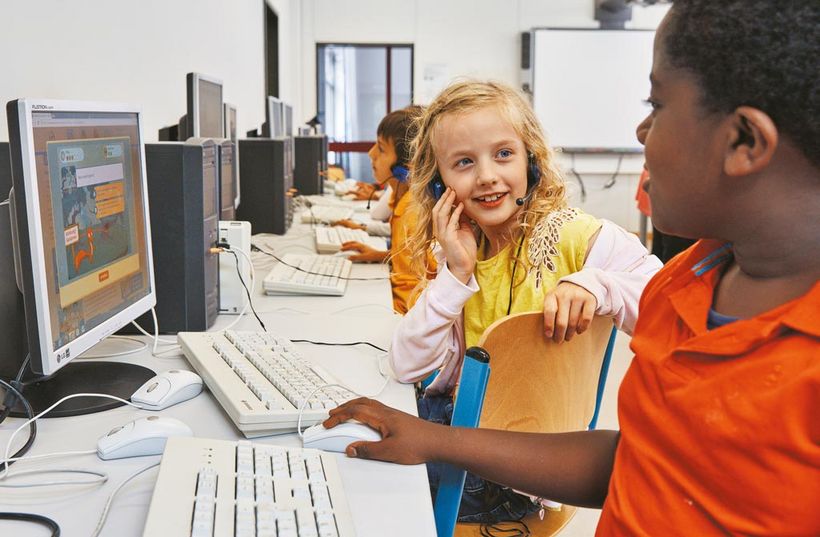 Ein Mädchen und ein Junge sitzen zusammen am Computer