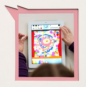 Ein Kind schaut auf ein Tablet mit bunten Kreisen