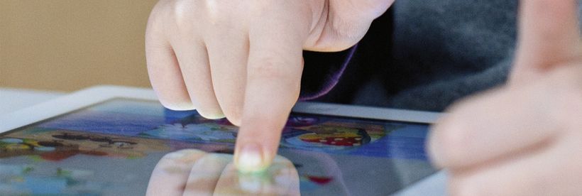 Ein Kinderfinger bedient ein Tablet