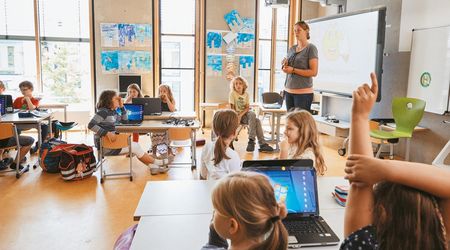 Eine Lehrerin steht vor Ihrer Grundschulklasse