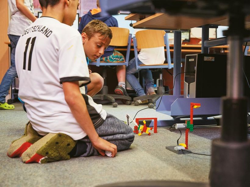 Zwei Grundschüler mit Ihrem programmieren Lego-Roboter