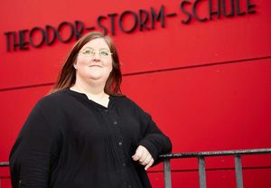 Catharina Frehoff steht vor der roten Wand der Theodor-Storm-Schule