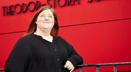 Catharina Frehoff steht vor der roten Wand der Theodor-Storm-Schule