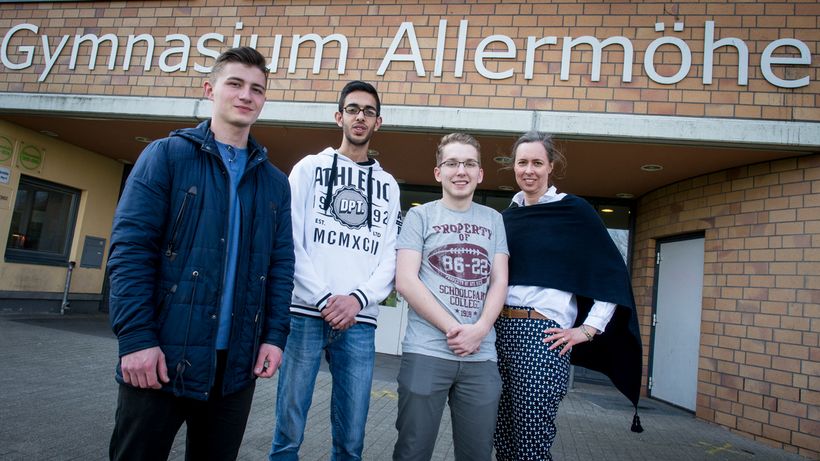 Lehrerin Kirsten Böttcher-Speckels steht mit drei Schülern vor dem Hamburger Gymnasium Allermöhe